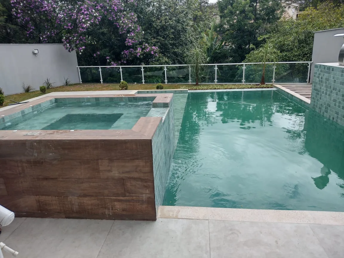 Piscina com spa elevado e deck amadeirado